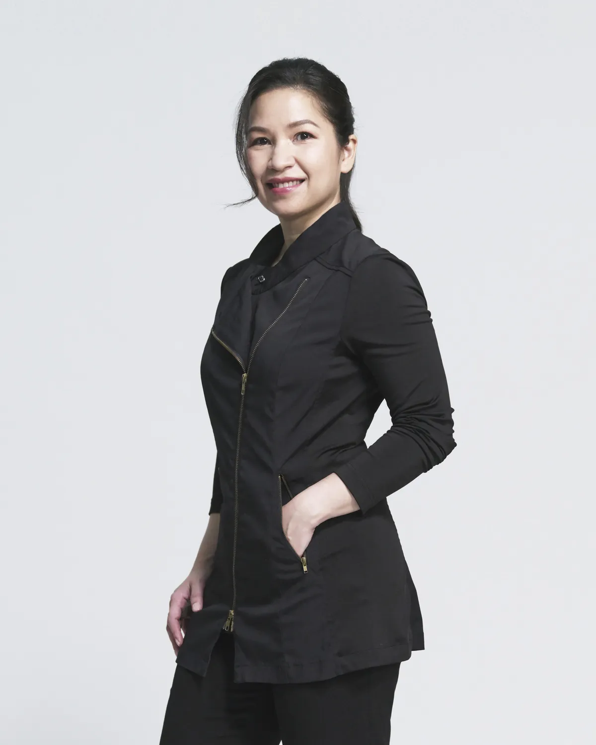 Dr Chang Fu Shi in a black clinical tunic, one hand in her pocket